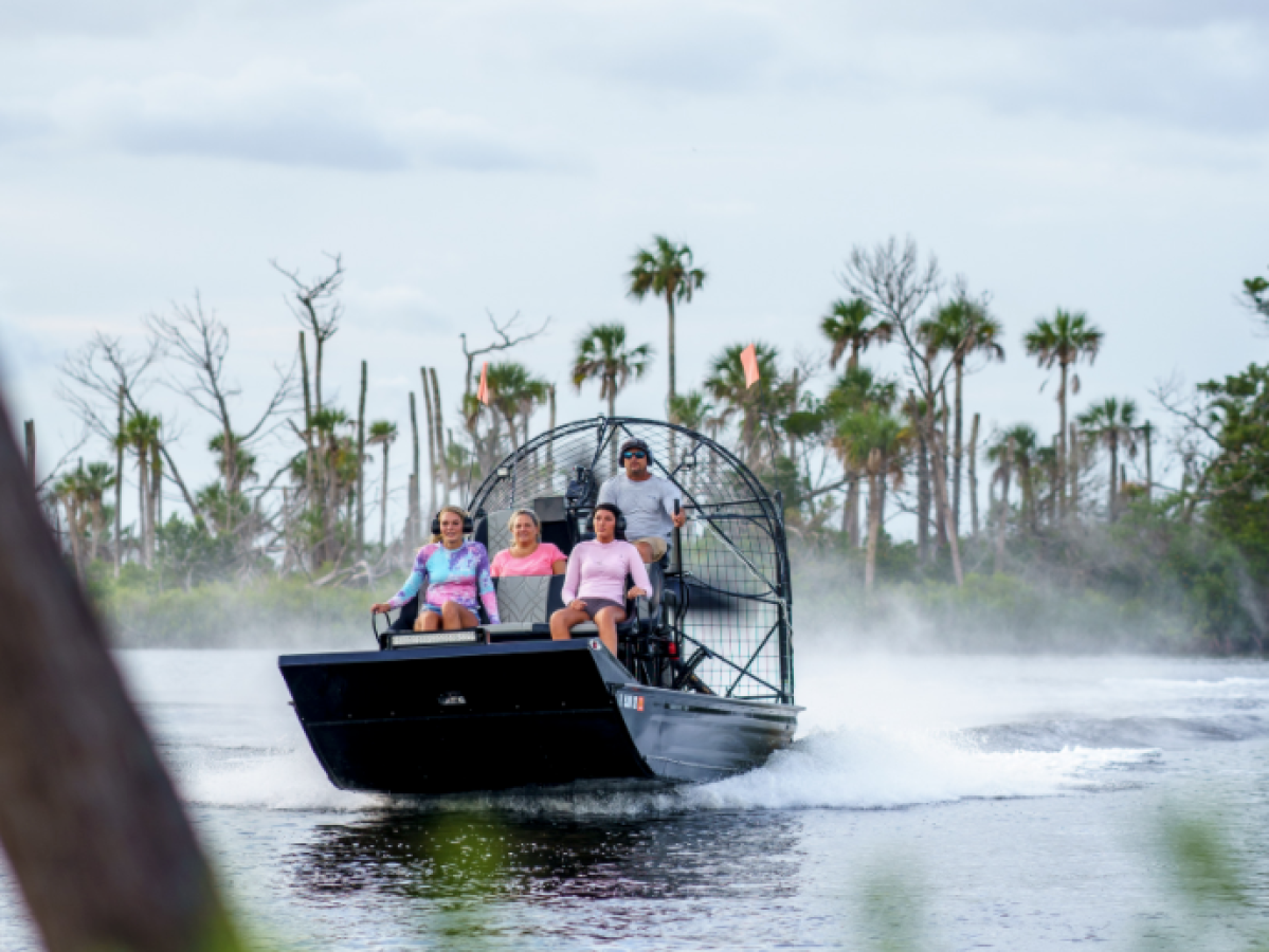 a man riding on the back of a boat in the water
