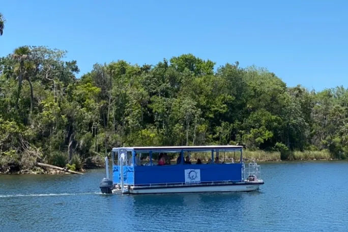 a boat traveling along a river next to a body of water